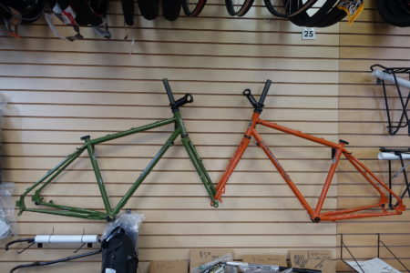 Two Black Mountain Cycles MCD frames displayed on wall one in green one in orange